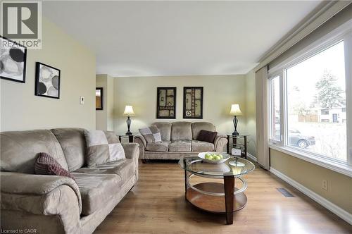 Spacious living area featuring large picture windows, wood-finish flooring, and light-toned walls - 114 Bakersfield Drive, Cambridge, ON - Indoor Photo Showing Living Room