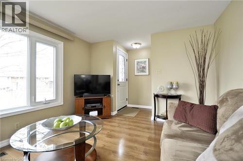 Living area featuring wood-finish flooring, light-toned walls, and a prominent window - 114 Bakersfield Drive, Cambridge, ON - Indoor Photo Showing Living Room