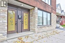 Front facade with brick and stone veneer, featuring dual entry doors with decorative glass panels and a large multi-pane window - 