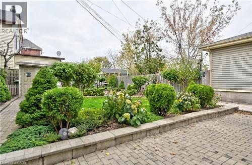 Expansive backyard featuring a manicured lawn, established garden beds, and mature shrubs - 1476 Barton Street E, Hamilton, ON - Outdoor
