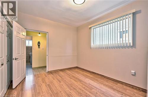 Room featuring wood-finish flooring, a window with vertical blinds, and a flush-mount ceiling light - 1476 Barton Street E, Hamilton, ON - Indoor Photo Showing Other Room