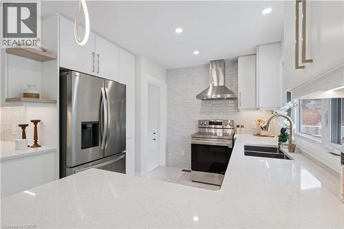 Modern kitchen featuring white cabinetry, a stainless steel appliance suite, white quartz countertops, a contemporary sink, and a tiled backsplash - 111 Ruskview Road, Kitchener, ON - Indoor Photo Showing Kitchen With Stainless Steel Kitchen With Double Sink With Upgraded Kitchen