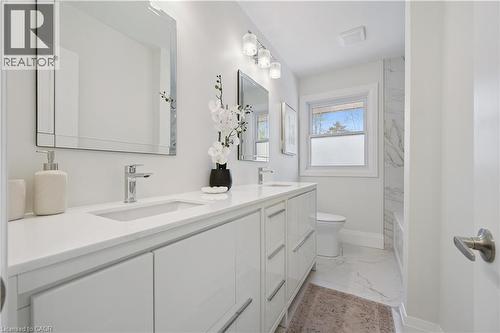 Dual vanity with integrated sinks and chrome fixtures, white cabinetry, quartz-style countertop, and rectangular mirrors - 111 Ruskview Road, Kitchener, ON - Indoor Photo Showing Bathroom