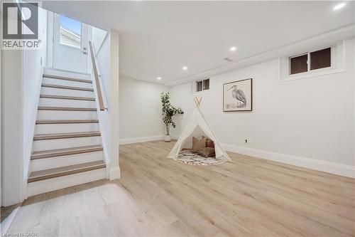 Spacious lower-level room featuring wood-finish flooring, recessed lighting, and white baseboards - 111 Ruskview Road, Kitchener, ON - Indoor Photo Showing Other Room