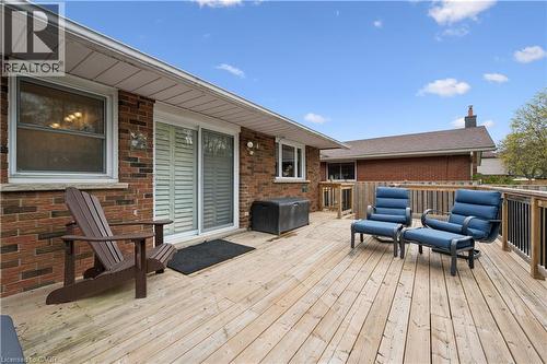 Spacious wooden deck featuring a brick exterior wall, white soffits, and a sliding patio door with interior shutters - 111 Ruskview Road, Kitchener, ON - Outdoor With Deck Patio Veranda With Exterior