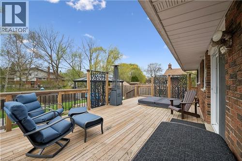 Spacious outdoor deck featuring natural wood flooring, dark privacy screens with tree-branch patterns, and a covered spa area - 111 Ruskview Road, Kitchener, ON - Outdoor With Deck Patio Veranda With Exterior
