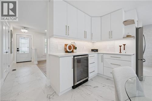 Bright kitchen featuring white cabinetry, light-toned countertops, a built-in beverage cooler, and under-cabinet lighting - 111 Ruskview Road, Kitchener, ON - Indoor Photo Showing Kitchen