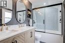 Full bath featuring double vanity and bath / shower combo with glass door - 624 Burgess Avenue, Hamilton, ON  - Indoor Photo Showing Bathroom 