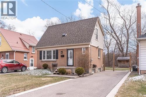 View of front of home with a shingled roof, a front yard, and brick siding - 624 Burgess Avenue, Hamilton, ON - Outdoor