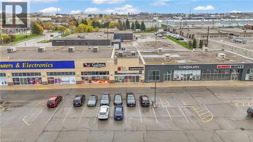 Retail plaza featuring multiple storefronts, a paved parking area, and rooftop HVAC units - 545 Hespeler Road, Cambridge, ON 