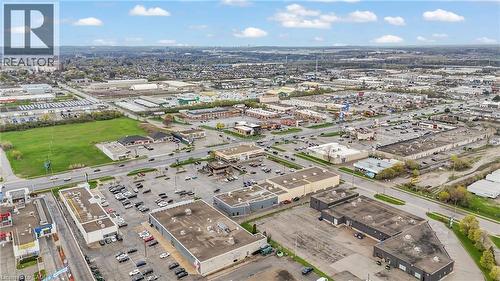 Expansive commercial landscape featuring multiple retail buildings with ample parking, adjacent to a large green space - 545 Hespeler Road, Cambridge, ON 