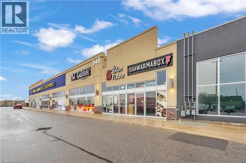 Commercial storefronts featuring large display windows and prominent signage - 545 Hespeler Road, Cambridge, ON 