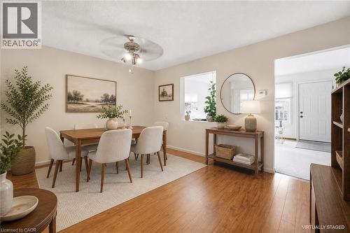 Dining area featuring wood-finish flooring, a ceiling fan with integrated lighting, and a pass-through window to an additional space - 299 Limeridge Ridge W Unit# 21, Hamilton, ON - Indoor Photo Showing Dining Room
