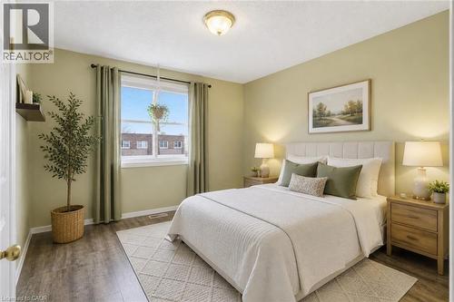 Spacious room featuring wood-finish flooring, a large window, light-toned walls, and a ceiling-mounted light fixture - 299 Limeridge Ridge W Unit# 21, Hamilton, ON - Indoor Photo Showing Bedroom