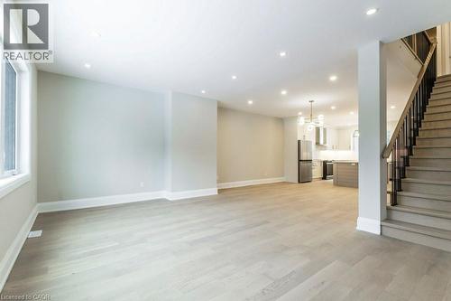 Unfurnished living room featuring light wood-style floors and suspended lighting - 1105 Main Street E, Cambridge, ON - Indoor Photo Showing Other Room