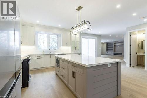 Kitchen with stainless steel appliances, a kitchen island, light wood-type flooring, and backsplash - 1105 Main Street E, Cambridge, ON - Indoor Photo Showing Kitchen With Upgraded Kitchen