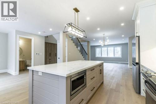 Kitchen featuring open floor plan, a kitchen island, stainless steel appliances, light stone countertops, and light wood-style floors - 1105 Main Street E, Cambridge, ON - Indoor Photo Showing Kitchen With Upgraded Kitchen