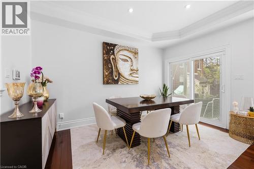 Dining area featuring dark wood-finish flooring and a tray ceiling with recessed lighting - 199 Hunter Street W, Hamilton, ON - Indoor Photo Showing Dining Room