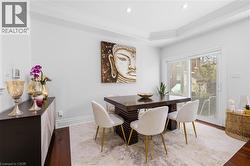 Dining area featuring dark wood-finish flooring and a tray ceiling with recessed lighting - 