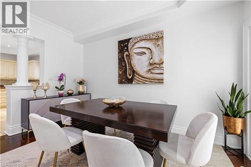 Formal dining area featuring dark wood-finish flooring, white crown molding, and a partial wall with an architectural column - 199 Hunter Street W, Hamilton, ON - Indoor Photo Showing Dining Room
