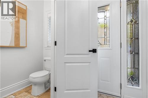 Entryway featuring a white paneled door with matte black hardware, sidelight with leaded glass, and stone tile flooring - 199 Hunter Street W, Hamilton, ON - Indoor Photo Showing Bathroom