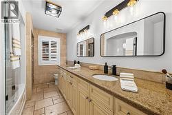 Double vanity featuring stone countertops and two rectangular mirrors with black frames - 