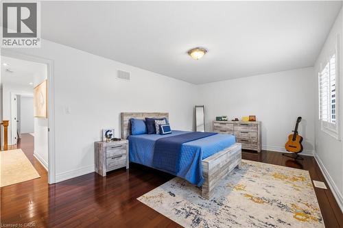 Spacious room featuring rich wood-finish flooring, white walls, and a ceiling-mounted light fixture - 199 Hunter Street W, Hamilton, ON - Indoor Photo Showing Bedroom