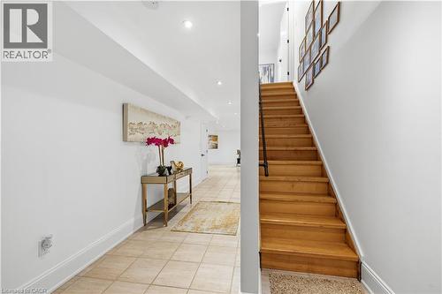 Hardwood staircase with dark metal handrail leading to an upper level - 199 Hunter Street W, Hamilton, ON - Indoor Photo Showing Other Room