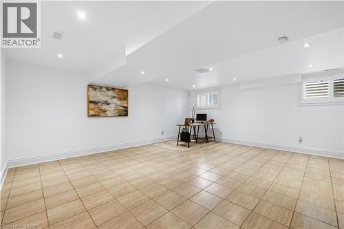 Spacious room featuring light-toned square tile flooring, recessed lighting, and white walls - 199 Hunter Street W, Hamilton, ON - Indoor
