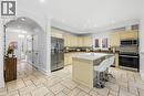 Spacious kitchen featuring light-toned cabinetry, stainless steel appliances, a center island with a stone countertop, and light-toned tile flooring - 199 Hunter Street W, Hamilton, ON  - Indoor Photo Showing Kitchen 