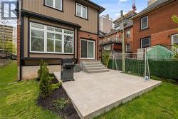 Rear exterior featuring a concrete patio, sliding glass door, and multiple windows with blinds - 