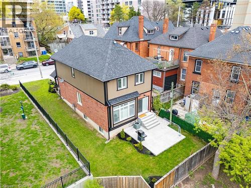 Rear exterior featuring a multi-level deck, sliding glass door access, and a manicured lawn - 199 Hunter Street W, Hamilton, ON - Outdoor