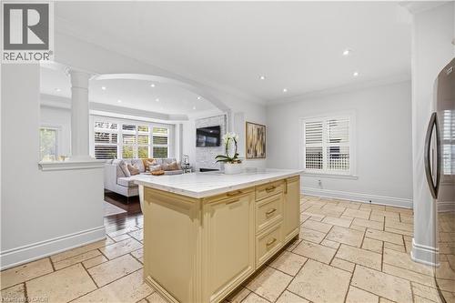 Kitchen island with a light-toned countertop, integrated cabinetry, and gold-finish hardware - 199 Hunter Street W, Hamilton, ON - Indoor