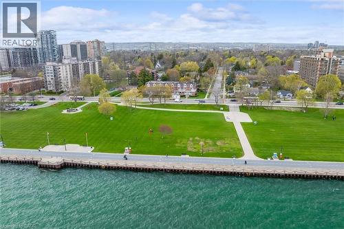 Expansive waterfront parkland featuring a paved pathway along the water's edge, extensive green space, and mature trees - 1389 Lakeshore Road, Burlington, ON - Outdoor With Body Of Water With View