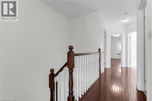 Upper-level hallway featuring rich wood-finish flooring, white walls, and a traditional wood and white spindle staircase railing - 1389 Lakeshore Road, Burlington, ON - Indoor Photo Showing Other Room