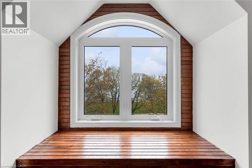 Arched window with white framing and sills, complemented by wood-finish wall paneling and a built-in wood-finish window seat - 1389 Lakeshore Road, Burlington, ON - Indoor Photo Showing Other Room