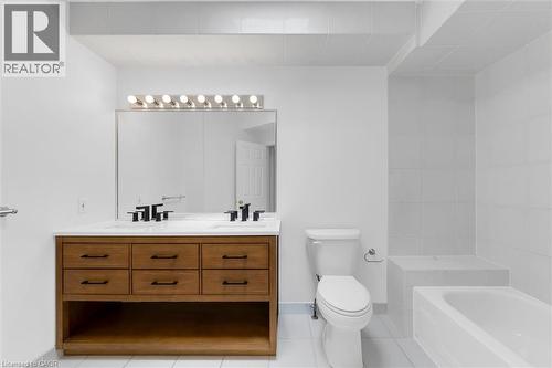 Bathroom featuring a dual-sink wood-finish vanity with white countertop, matte black fixtures, and a large mirror - 1389 Lakeshore Road, Burlington, ON - Indoor Photo Showing Bathroom