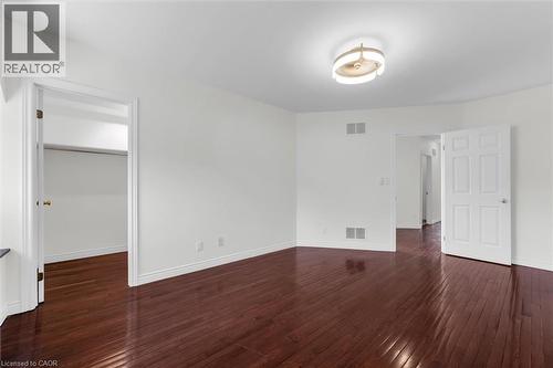 Spacious room featuring rich wood-finish flooring, crisp white walls, and a contemporary ceiling light fixture - 1389 Lakeshore Road, Burlington, ON - Indoor Photo Showing Other Room