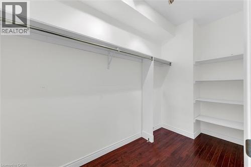 Walk-in closet featuring wood-finish flooring, built-in shelving, and a hanging clothes rod - 1389 Lakeshore Road, Burlington, ON - Indoor With Storage