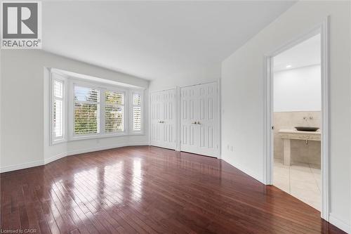Hardwood-style flooring throughout a room featuring a bay window with plantation shutters - 1389 Lakeshore Road, Burlington, ON - Indoor Photo Showing Other Room