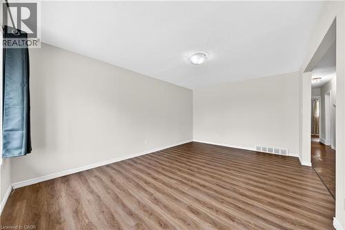 Spacious room featuring wood-finish flooring, light-toned walls, and white trim - 34 Avenue Road, Cambridge, ON - Indoor Photo Showing Other Room
