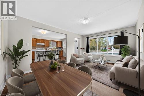 Open-concept living area featuring wood-finish flooring throughout, a large picture window, and a clear sightline into the kitchen - 34 Avenue Road, Cambridge, ON - Indoor