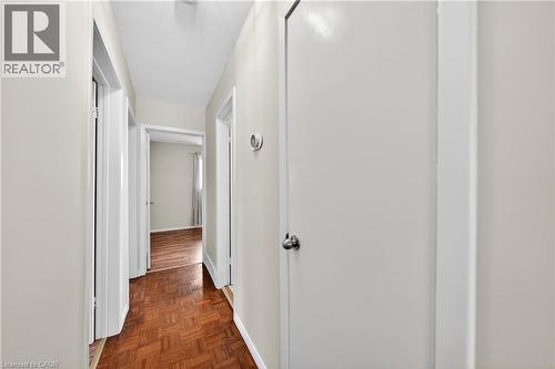 Hallway featuring wood-finish parquet flooring, light neutral wall paint, white trim, and doors with chrome hardware - 34 Avenue Road, Cambridge, ON - Indoor Photo Showing Other Room