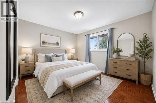 Bedroom featuring wood-finish flooring, light-toned wall paint, and a built-in window with blue drapery - 34 Avenue Road, Cambridge, ON - Indoor Photo Showing Bedroom