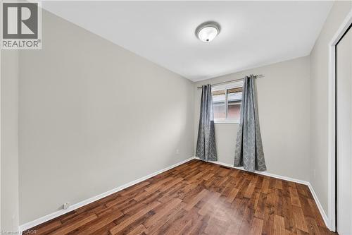 Room featuring wood-finish flooring, a window with window treatments, a flush-mount ceiling light fixture, and light-toned wall paint - 34 Avenue Road, Cambridge, ON - Indoor Photo Showing Other Room