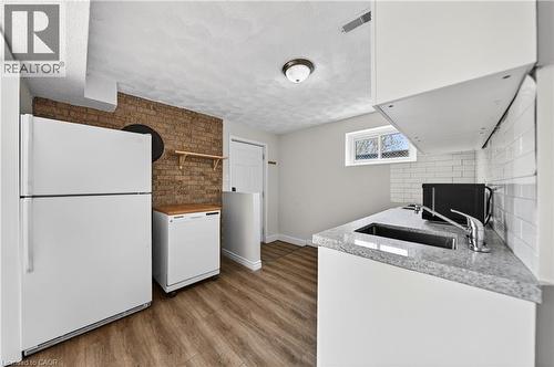 Efficient kitchen area featuring white cabinetry, a single-basin sink, and granite-finish countertops - 34 Avenue Road, Cambridge, ON - Indoor Photo Showing Kitchen