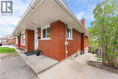 Brick exterior with white window frames and a covered front entry - 34 Avenue Road, Cambridge, ON - Outdoor With Exterior