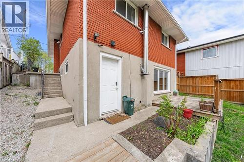 Red brick exterior with white trim windows and a concrete foundation - 34 Avenue Road, Cambridge, ON - Outdoor With Deck Patio Veranda With Exterior