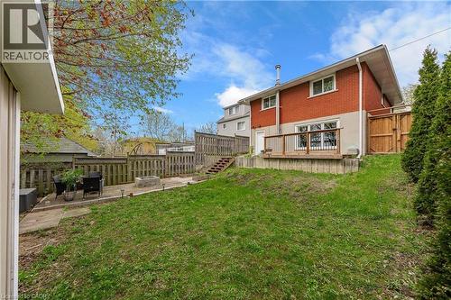 Expansive backyard featuring a multi-level layout with a grass lawn, a lower concrete patio, and a raised wood deck - 34 Avenue Road, Cambridge, ON - Outdoor With Deck Patio Veranda