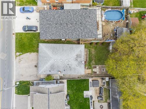 Two residential properties featuring asphalt shingle roofs and private outdoor spaces - 34 Avenue Road, Cambridge, ON - Outdoor With Above Ground Pool